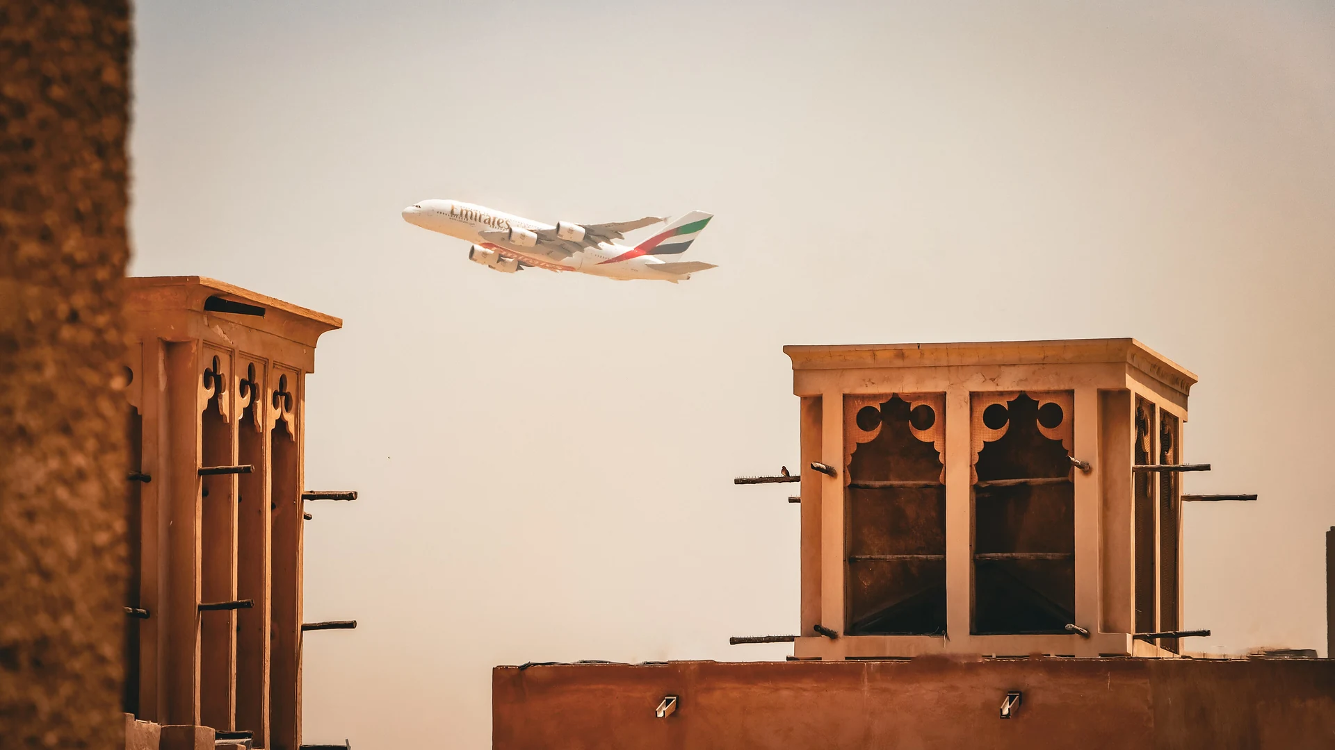 Wind towers in Al Fahidi Historical Neighbourhood with a jet flying overhead