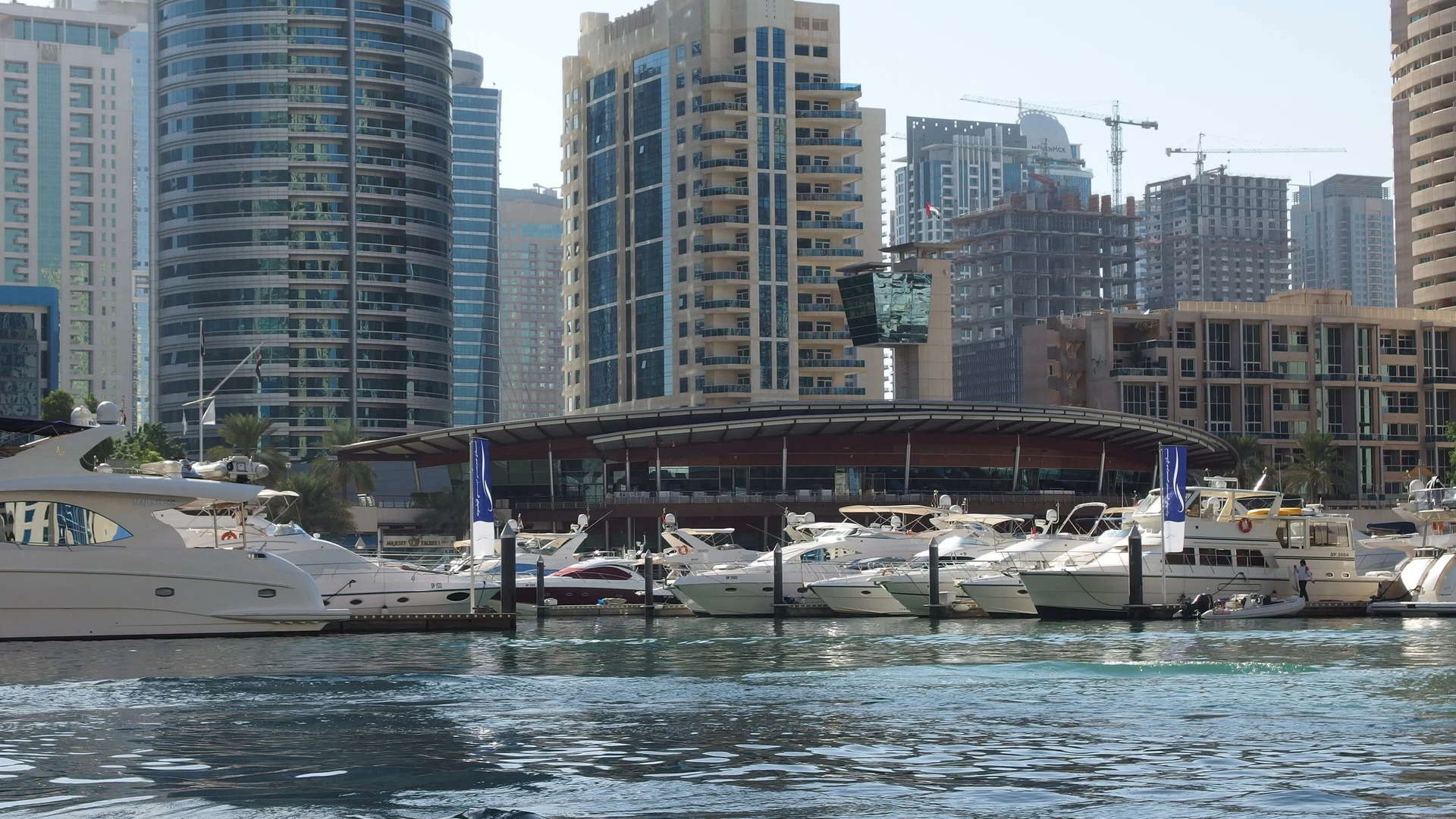 Motor yachts moored at Dubai Marina with the marina's high-rise towers behind